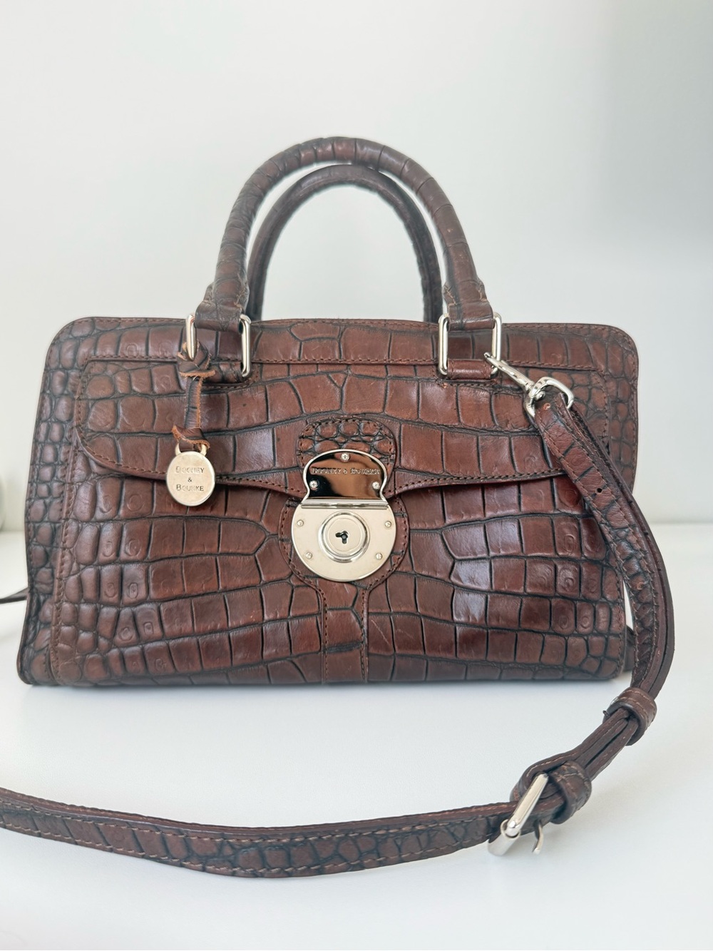 Dooney & Bourke, crafted from rich brown crocodile-embossed leather